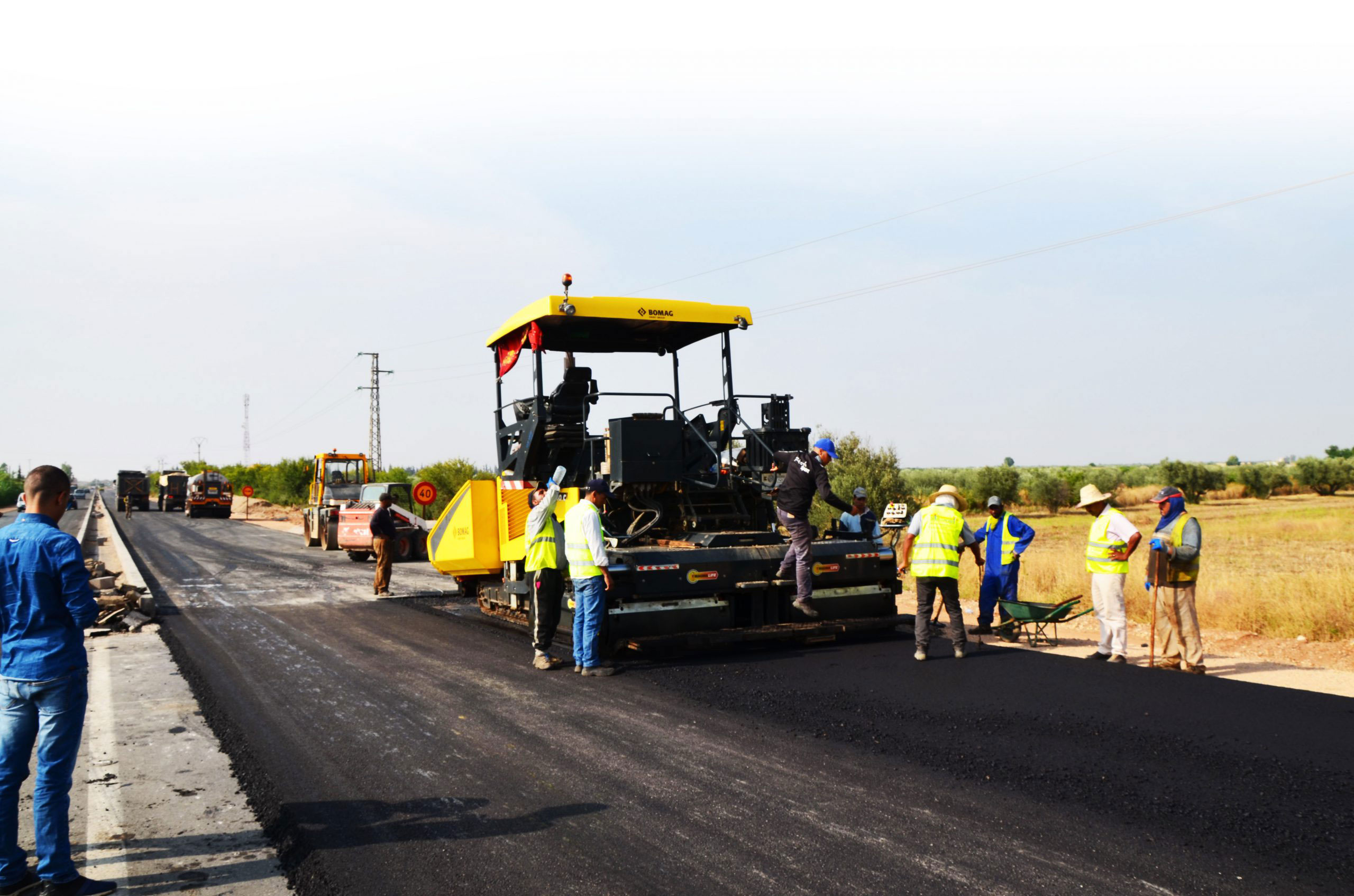 Pose d’enrobé avec finisseur et équipe de chantier